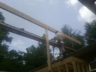 Carpenter setting a ridge beam over a new addition frame — Ice Dam Removal by Roofing Brothers in Tennessee Ridge