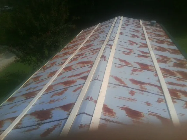 Rusted metal roof panels with new wood purlins before replacement — Storm Damage Roof Repair in Tennessee Ridge by Roofing Brothers