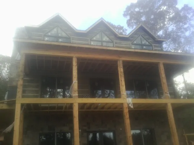 Dormers and porch framing on a large log home under construction — Roof Coating work by our crew in Tennessee Ridge